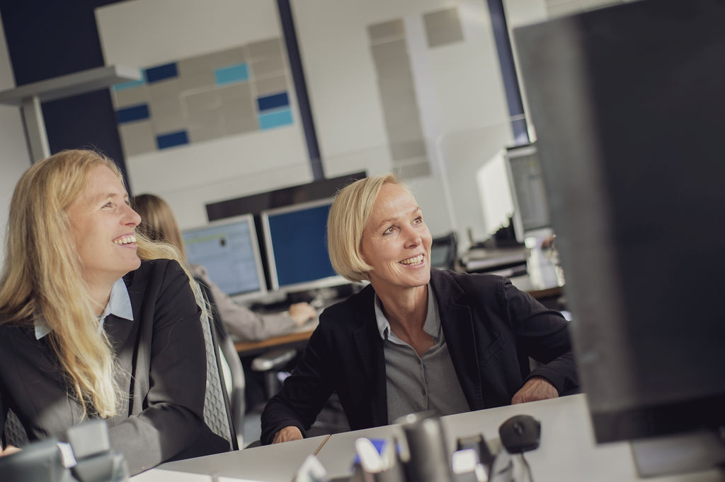 Zwei Frauen sitzen vor dem Computer